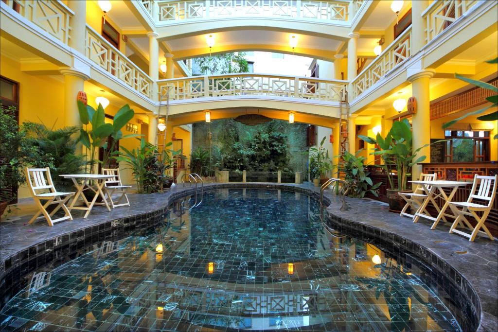 会安平盛湾1号酒店的酒店设有一个室内游泳池,配有桌椅
