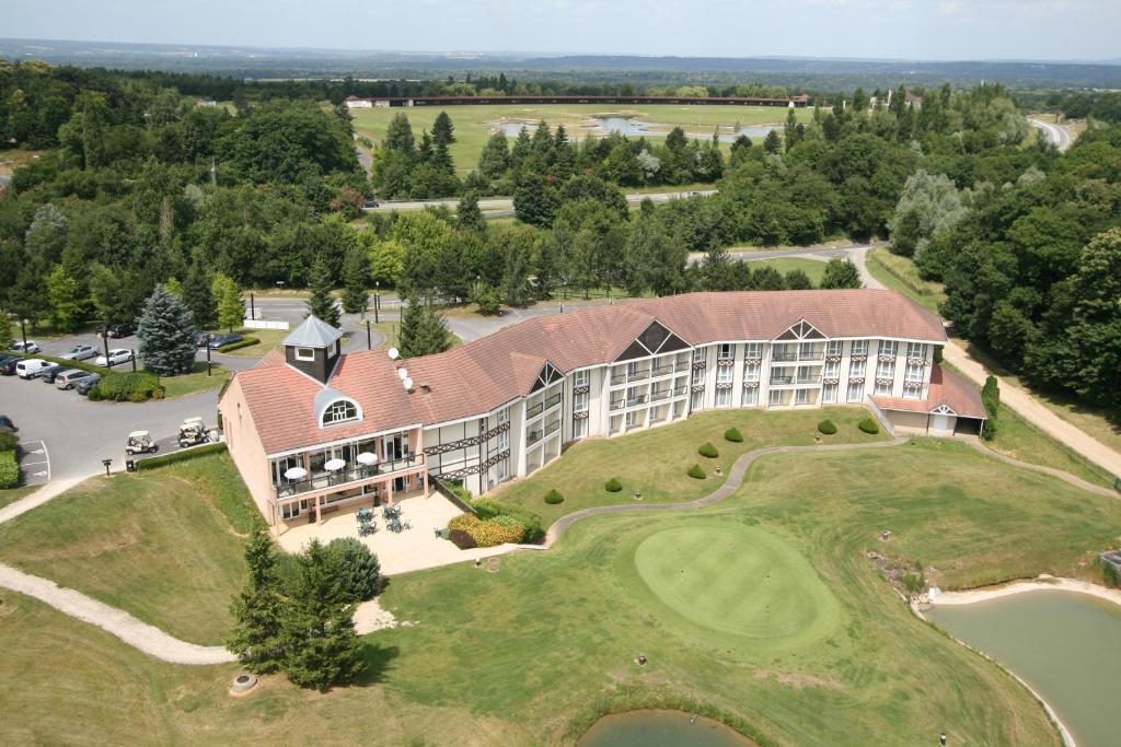 吕扎什格尔福蒙格力风酒店的享有带高尔夫球场的度假建筑的空中景致