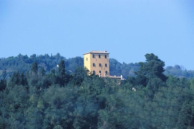 La TorracciaLocanda Di Villa Torraccia的一座树冠茂密的山顶上的建筑