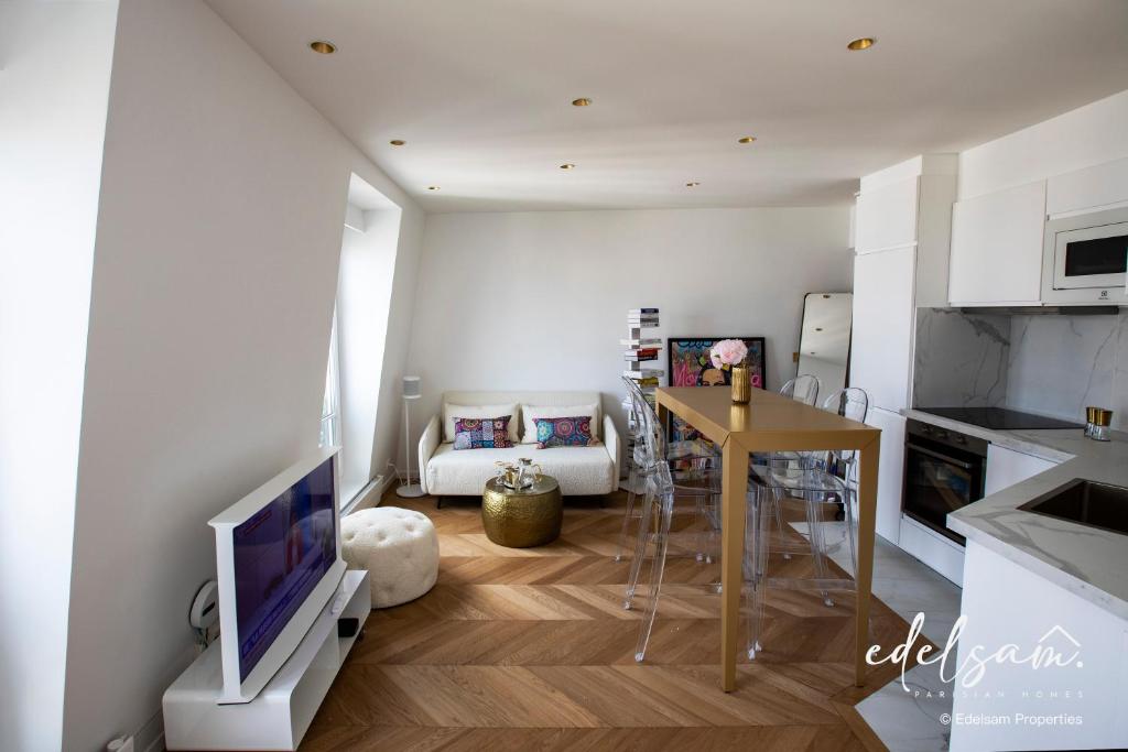 巴黎Paris Parc Monceau by Edelsam的厨房以及带电视和桌子的客厅。