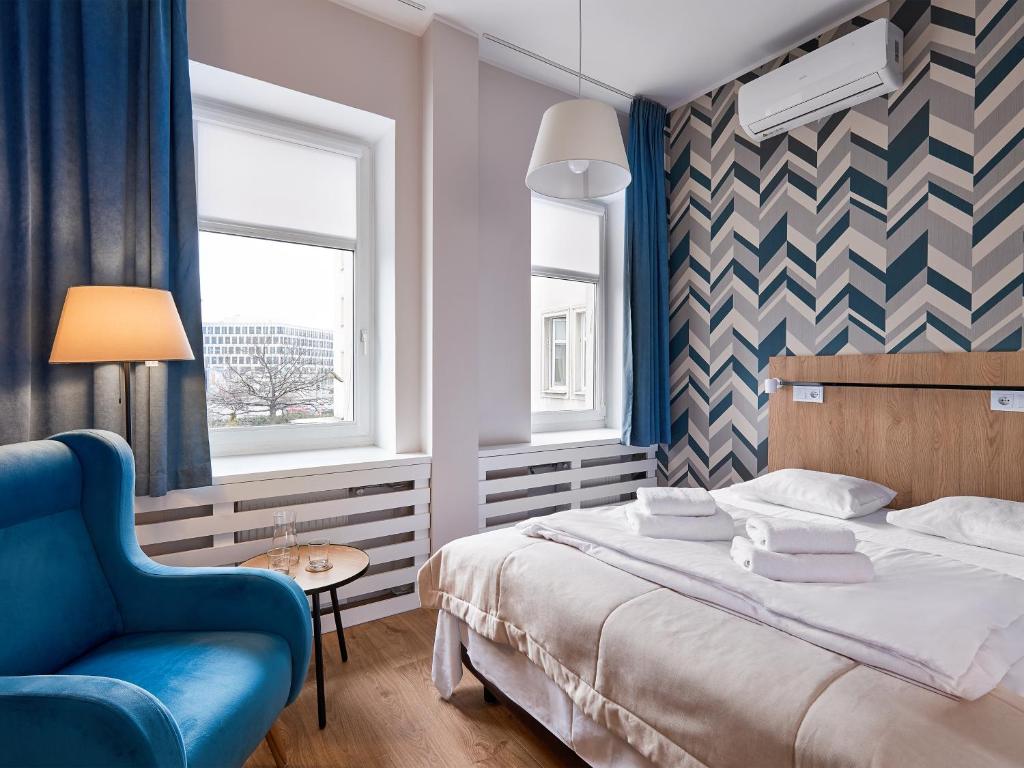 波兹南Hotel Traffic Poznań Stare Miasto的一间卧室配有一张床和一张蓝色椅子