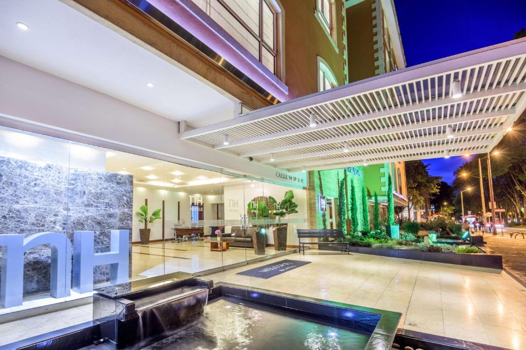 波哥大NH波哥大帕维永罗伊尔酒店 的一座建筑的中间有一个游泳池