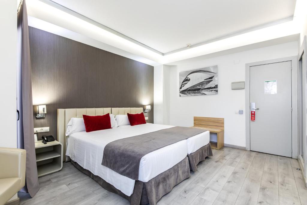 瓦伦西亚瑞纳萨甜美酒店 的一间卧室配有一张带红色枕头的大床