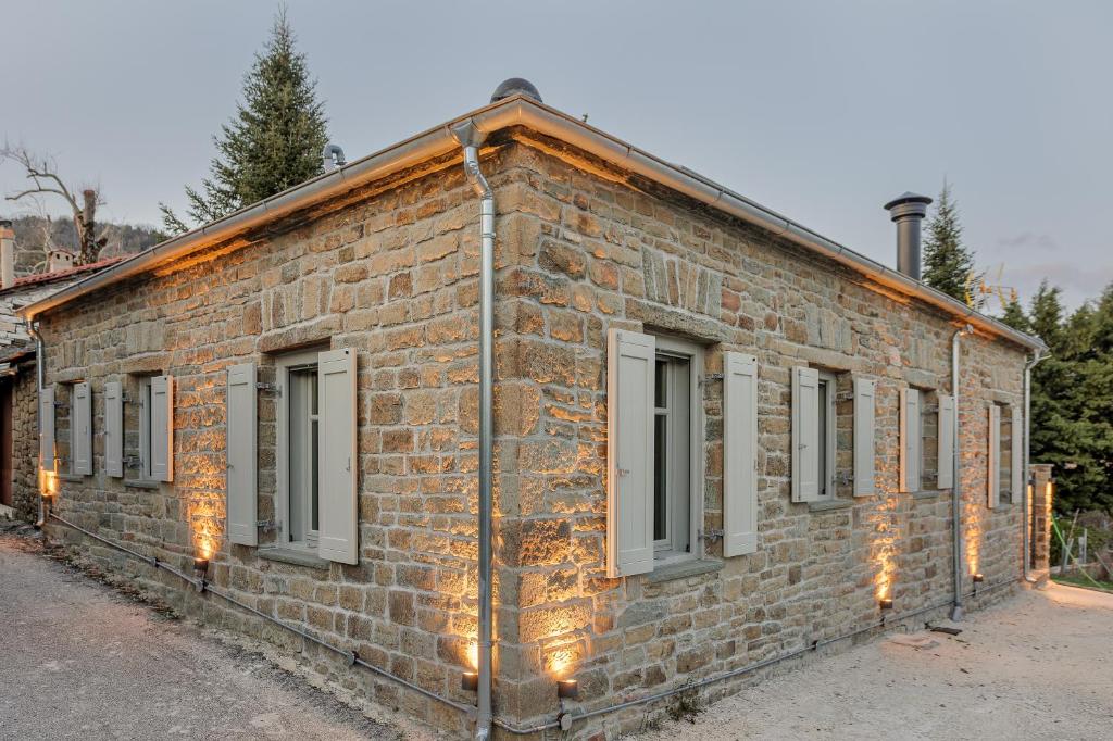 EllinikónLozArt Traditional Stone House的砖砌的建筑,有窗户和灯