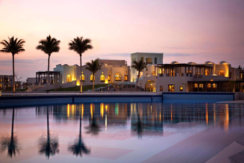 塞拉莱塞拉莱罗塔纳度假酒店的黄昏时分带游泳池和棕榈树的度假村