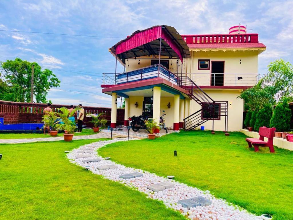 布巴内什瓦尔Goroomgo Bottom Up Villa Swimming Pool Bhubaneswar的一座红色屋顶和绿色草坪的房子