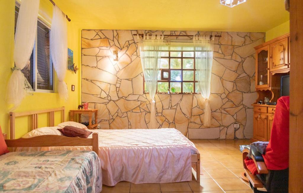 巴列埃尔莫索One bedroom house with enclosed garden and wifi at Vallehermoso 3 km away from the beach的一间卧室设有两张床和石墙