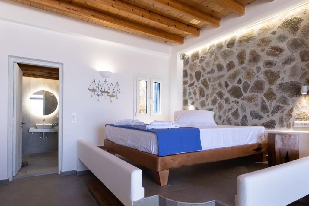 基莫洛斯岛Ωκεανίς Κίμωλος的一间卧室设有一张床和石墙