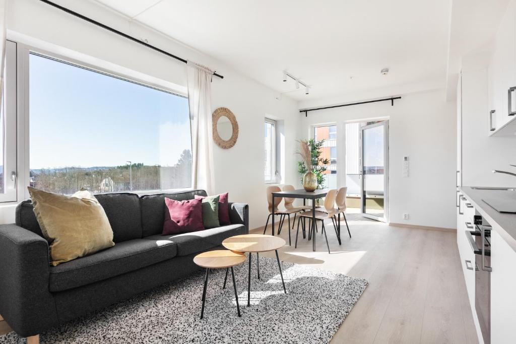 特隆赫姆Forenom Serviced Apartments Trondheim的客厅配有黑色沙发和桌子