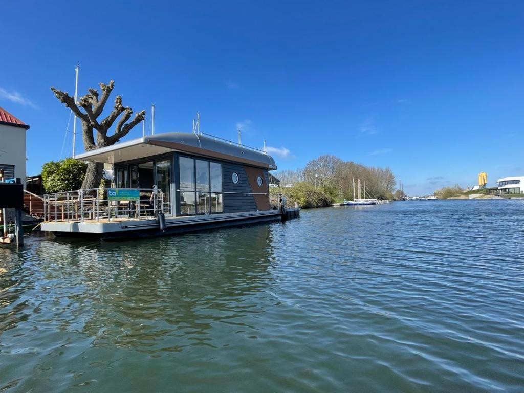 坎珀兰Houseboat Kamperland的坐在河水上的船屋