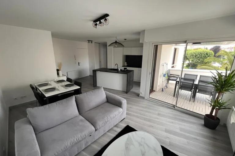 比亚里茨Apartment hyper-center Biarritz with parking的一间带白色沙发的客厅和一间厨房