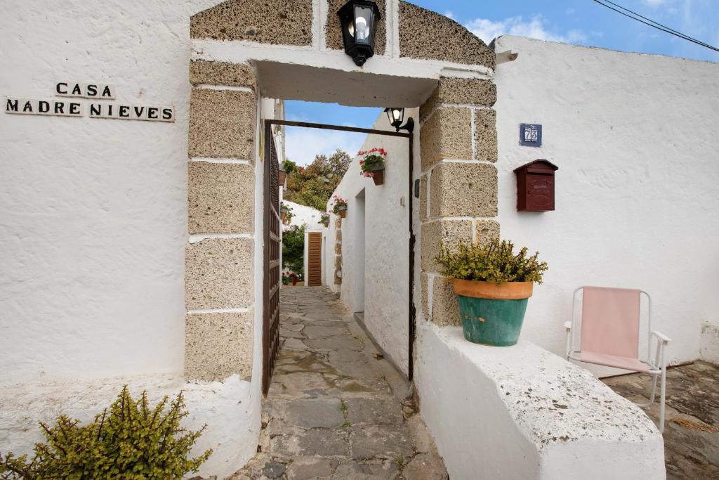 FasniaCasa Rural Madre Nieves的白色建筑的入口,有盆栽植物