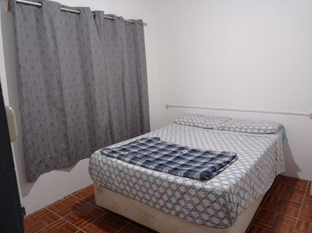 杜拉斯诺Tuc com的一间带床和窗帘的小卧室