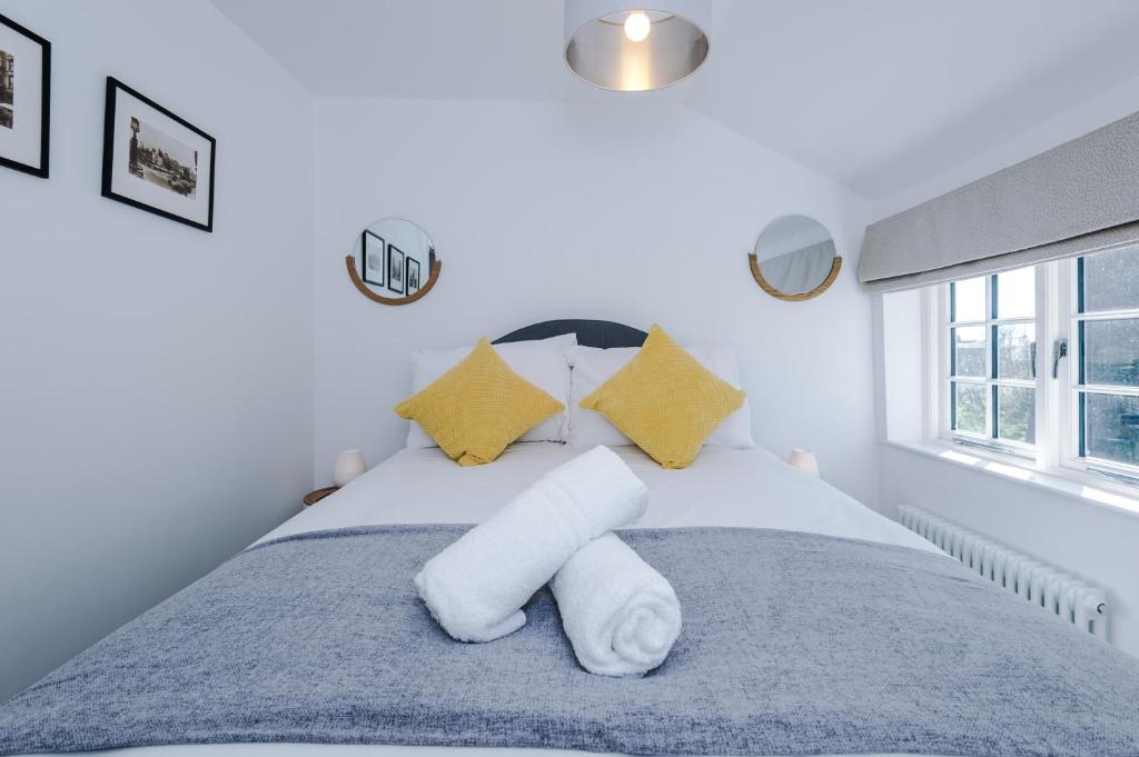 切斯特Stylish Home with Canal Views的一间卧室配有带白色床单和黄色枕头的床。