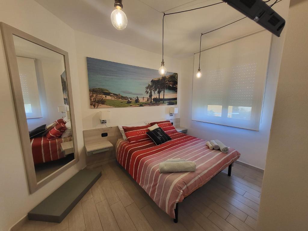 托雷斯港Struttura Re Barbaro的一间卧室配有一张带红色床单和镜子的床