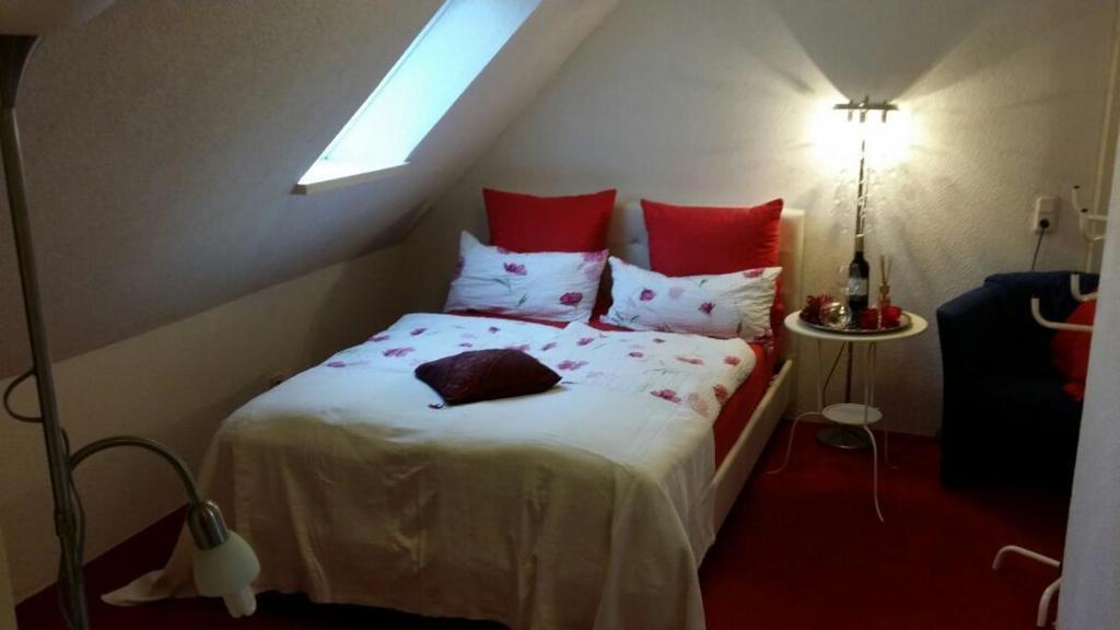 桑德Auf dem alten Deich的卧室配有带红色枕头的白色床