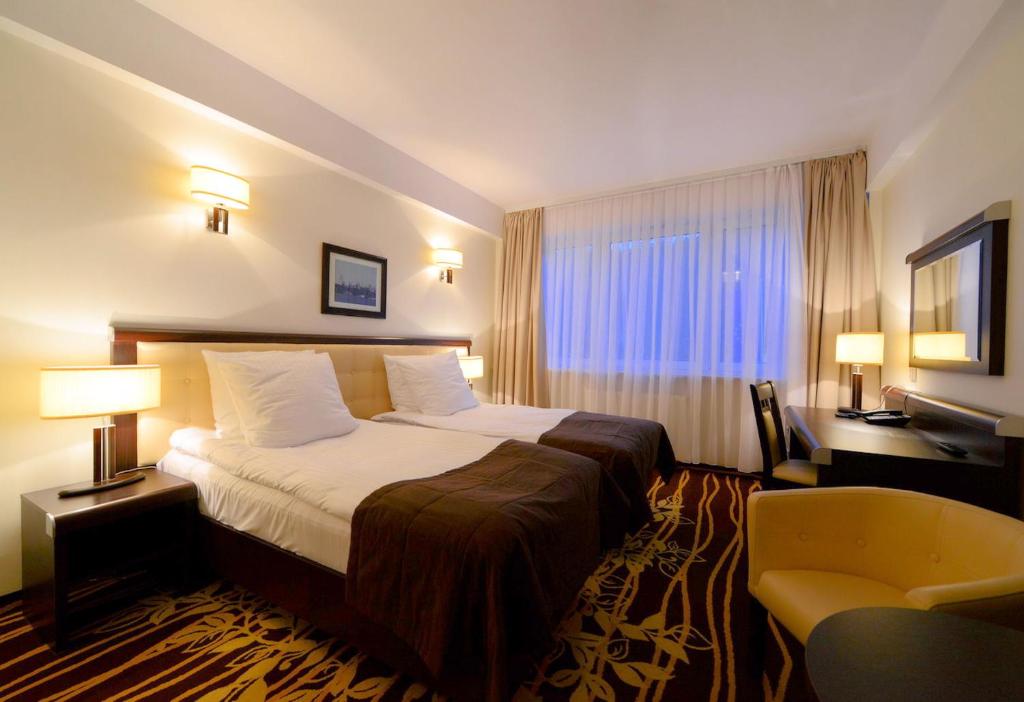 露米雅格丁尼亚法尔图姆商务酒店的配有一张床和一把椅子的酒店客房