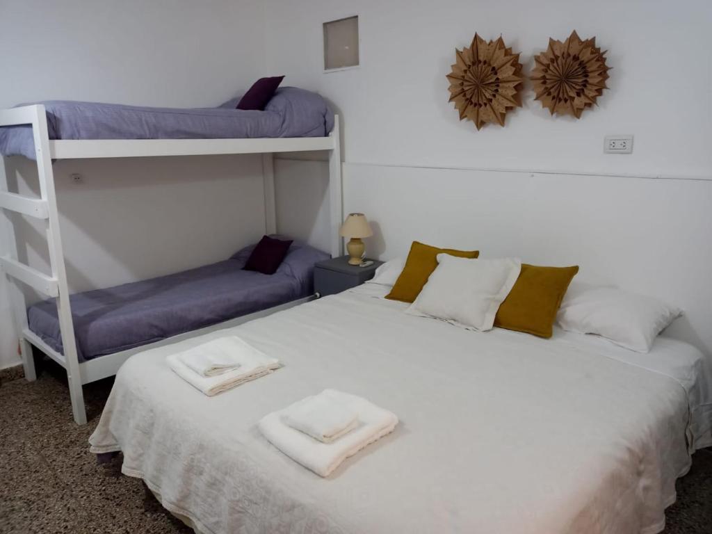 卡特里耶尔Cacique Catriel "PLANTA BAJA" check-in flexible的一间卧室设有两张双层床和梯子