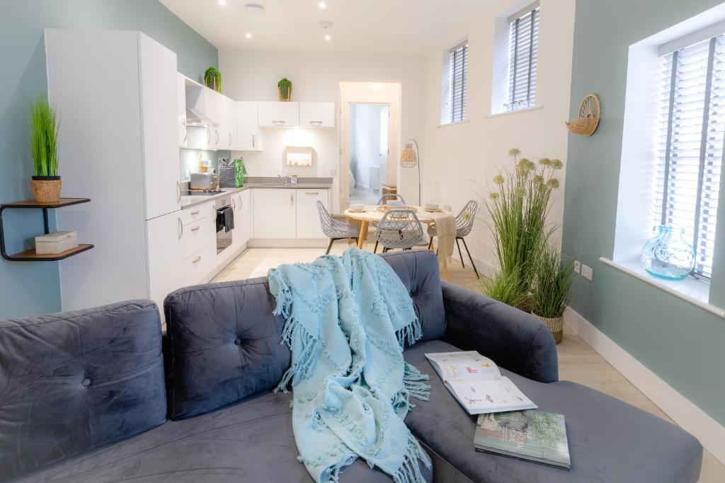 南安普敦Courtyard Retreat的一间带蓝色沙发的客厅和一间厨房