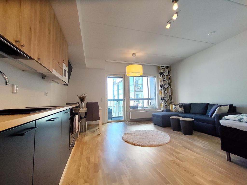 坦佩雷Fully Equipped New Apartment With Free Parking的厨房以及带沙发和桌子的客厅。