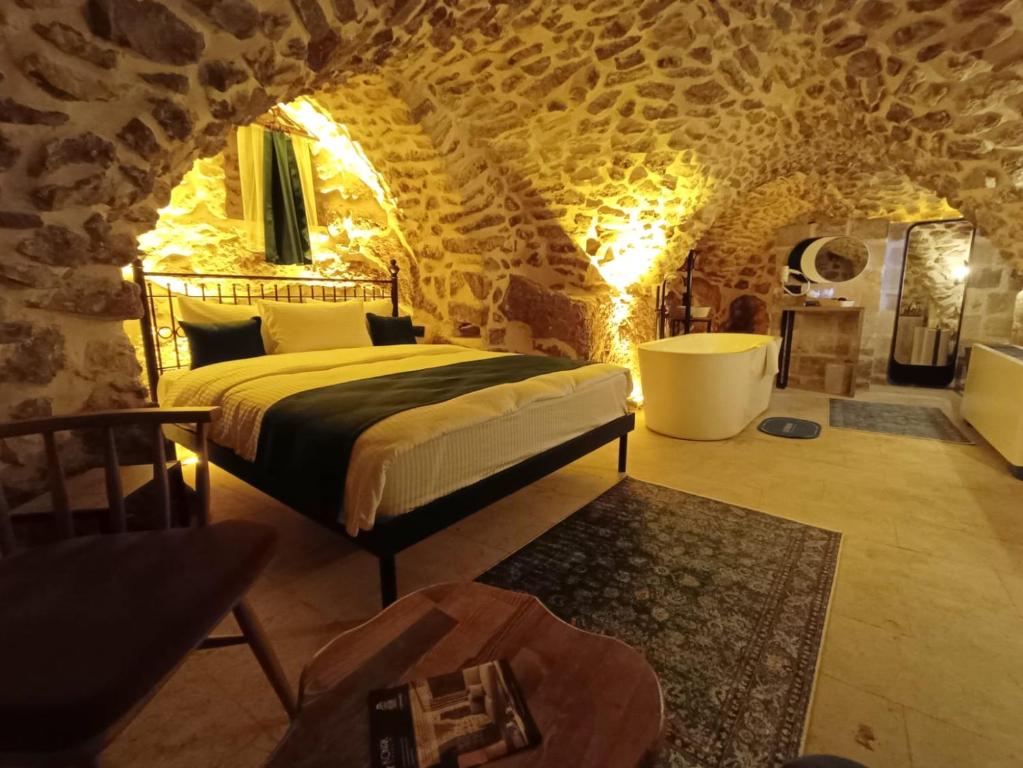 马尔丁TUĞMANER Small House AJAR的一间卧室设有一张床和石墙