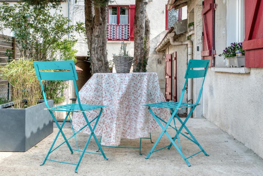 朗布依埃Cottage Au Coin du Feu的两张蓝色的椅子和一张桌子及一张桌布