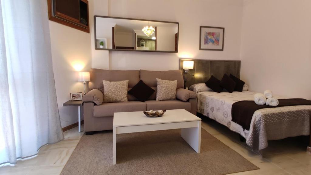 阿尔卡拉德瓜代拉H Los Molinos AT的一间卧室配有一张床、一张沙发和一张桌子