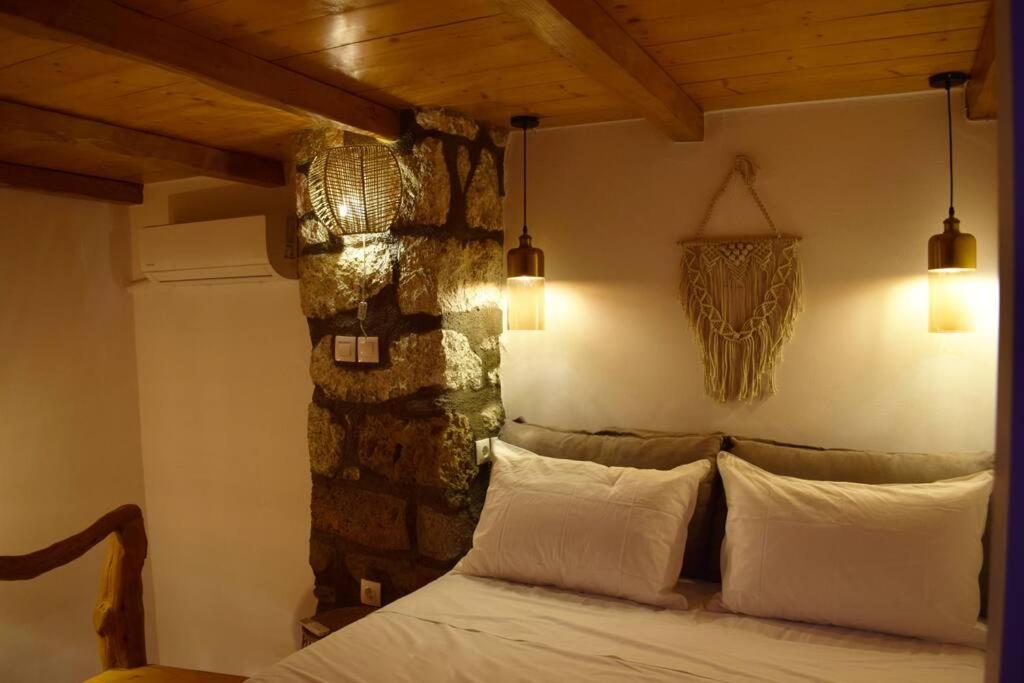 ZefiríaHemeros Villa的一间卧室设有一张床和石墙
