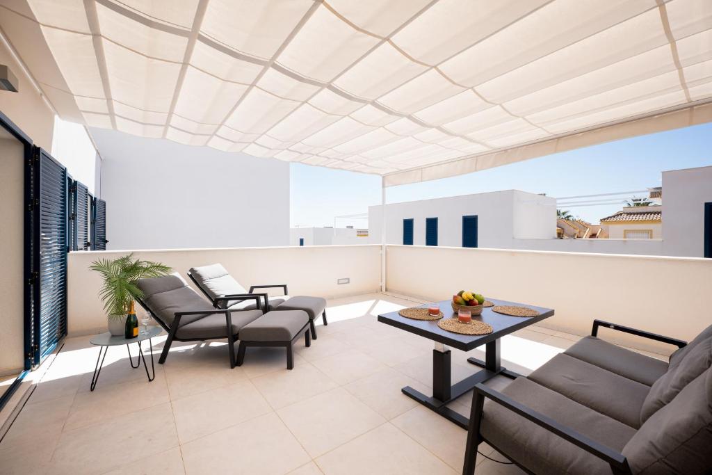 弗拉门卡海滩Turquesa del Mar - Max Beach Golf - Large Sunny Terrace Apartment的阳台设有带椅子和桌子的客厅