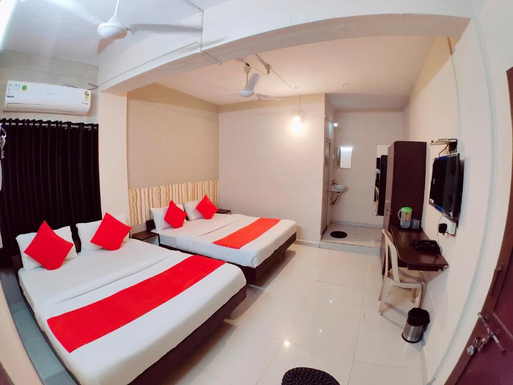 贾姆讷格尔Hotel Nawanagar Residency的酒店客房 - 带两张带红色枕头的床