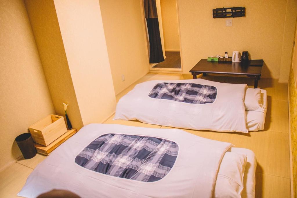 神户WASEIDOU ZEN - Vacation STAY 19522v的小型客房配有两张床和一张桌子。
