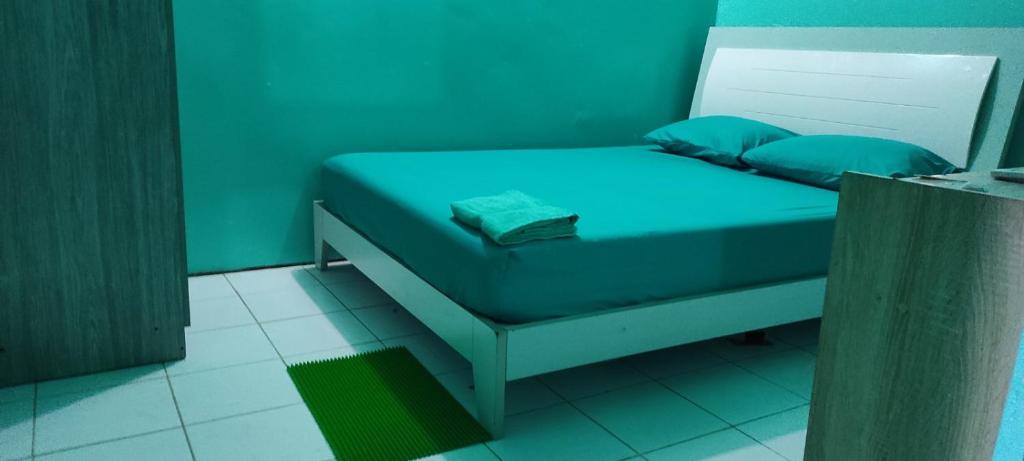 马累faTuur Inn的一张带蓝色床单和蓝色枕头的小床