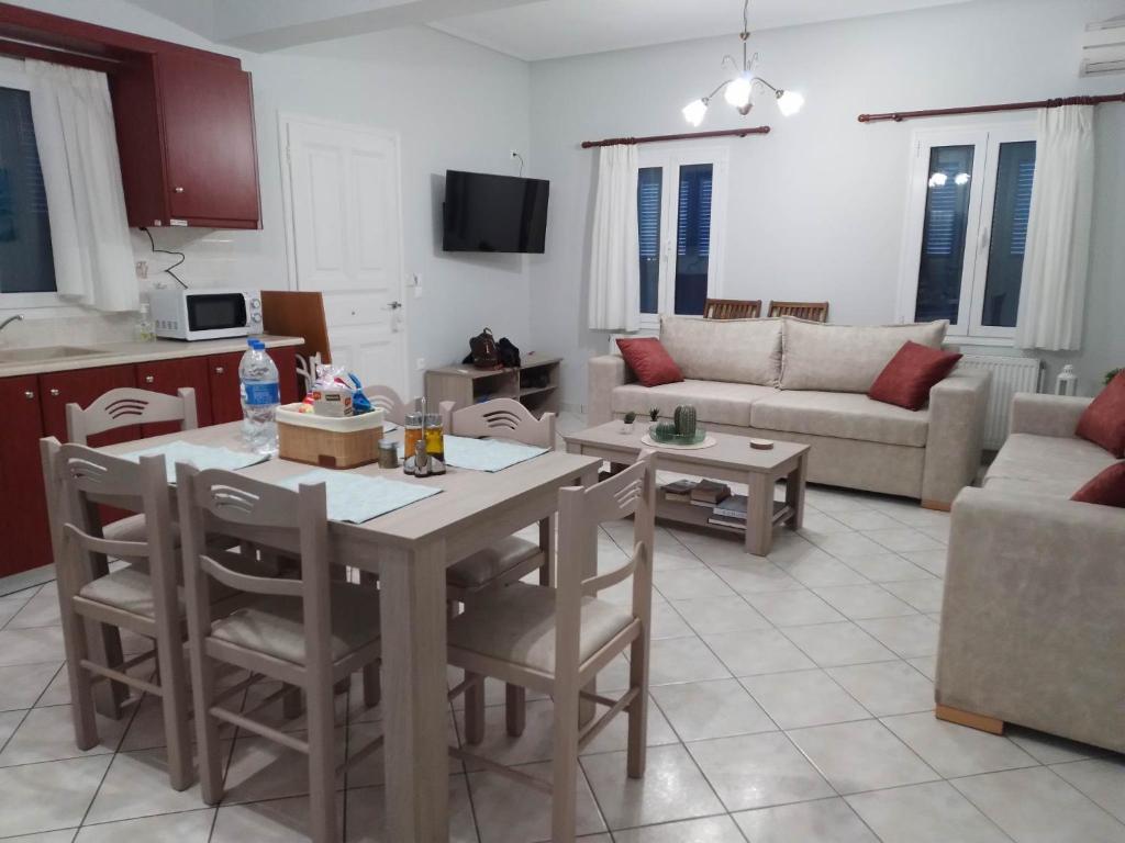 ÓrmosLefakis Aegean Breeze Apartment的厨房以及带桌椅的起居室。