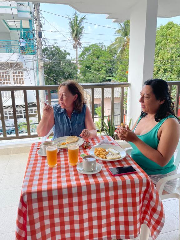 托卢Casa Inés Tolú的两个坐在餐桌上吃食物的女人