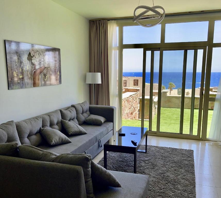 赫尔格达Apartment Azzura Sahl Hasheesh with private garden的带沙发的客厅,享有海景