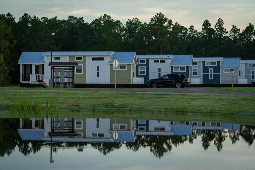 格尔夫海岸Gulf Shores RV Resort的一排移动房屋,靠近一排水体