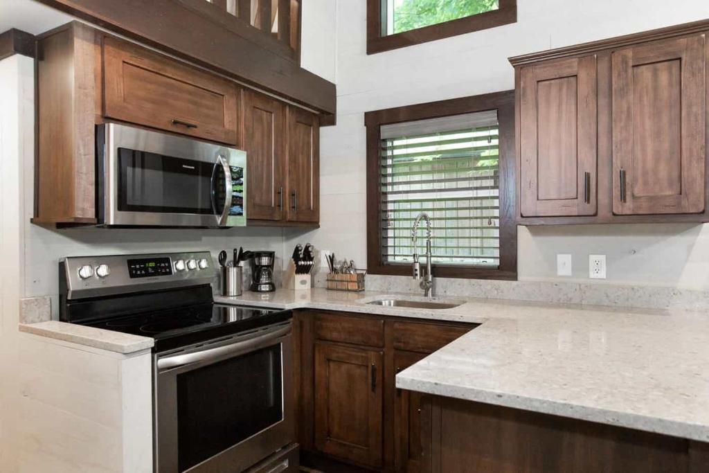 格尔夫海岸Gulf Shores RV Resort的厨房配有木制橱柜和炉灶烤箱。