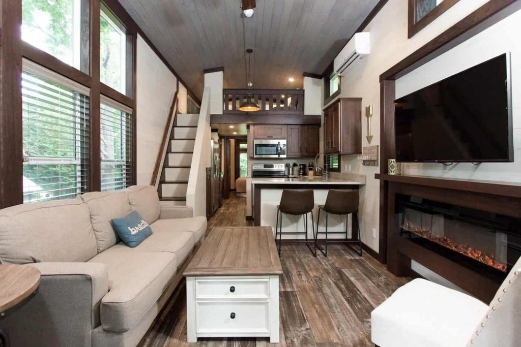格尔夫海岸Gulf Shores RV Resort的一间客厅,客厅配有沙发和电视,位于一个小房子里