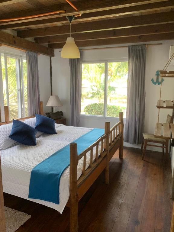 蒙特里科Casa, Cabo Tortugas, Monterrico的一间卧室配有一张带蓝色枕头的大床