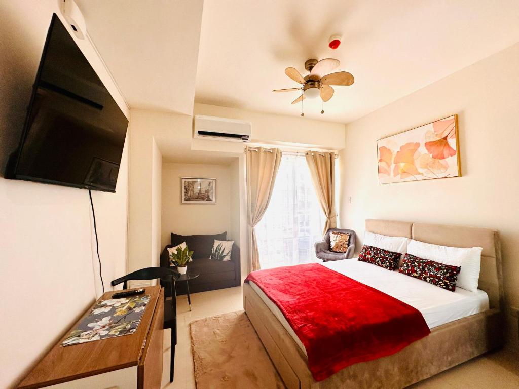 达沃市Lengs Place 1 - Studio Unit at Inspiria Condo Beside Abreeza Mall Davao City的一间卧室配有一张带红色毯子的床
