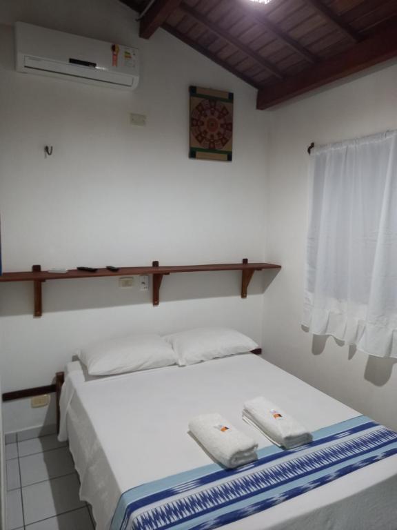 杰里科科拉Pousada do farol的一间卧室配有一张床,上面有两条毛巾