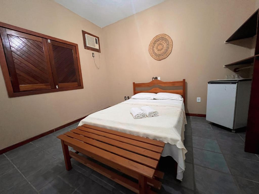 普拉杜Pousada Pitanga的一间卧室配有一张床和长凳