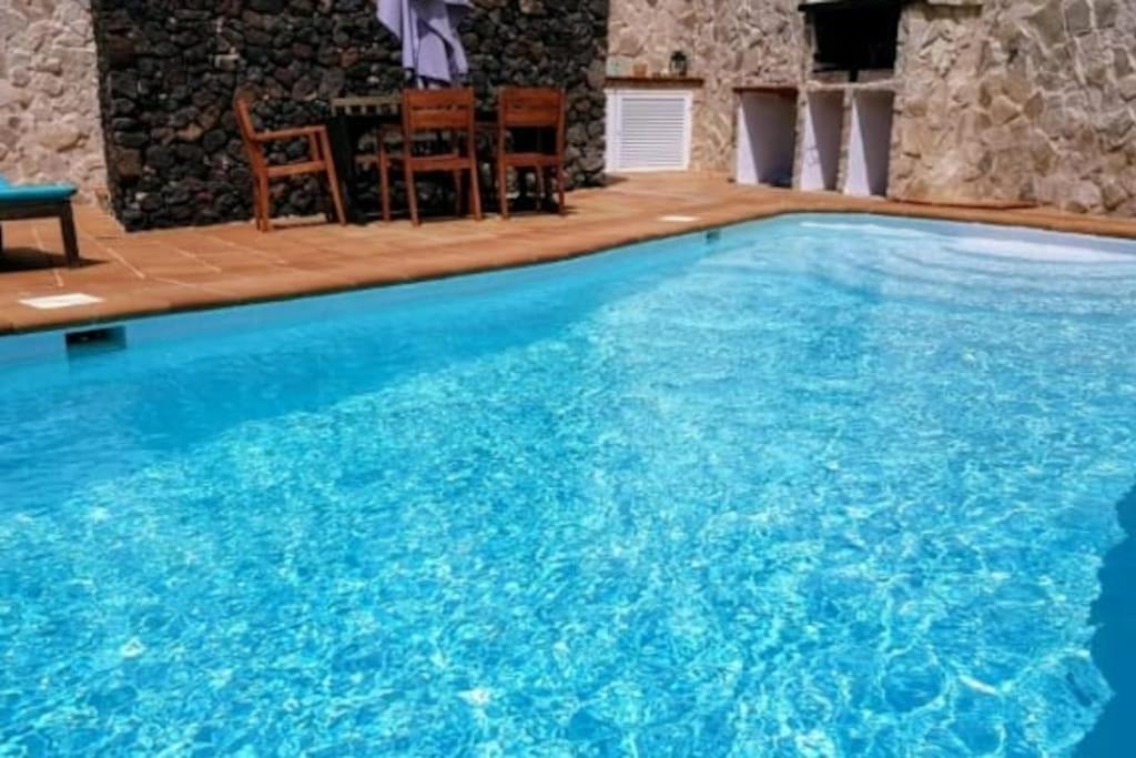 蒂纳霍LANZATE!的一个带桌椅的大型蓝色游泳池