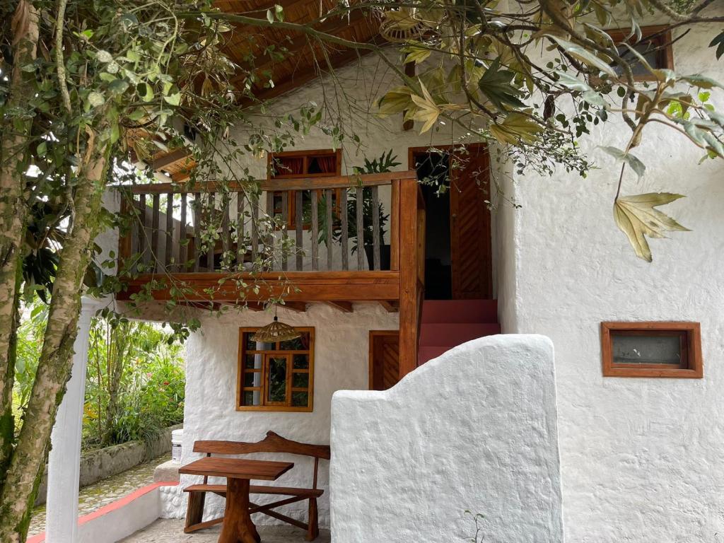 奥塔瓦洛Casa Museo - Naturaleza y Tradición的房屋设有木制阳台和木桌