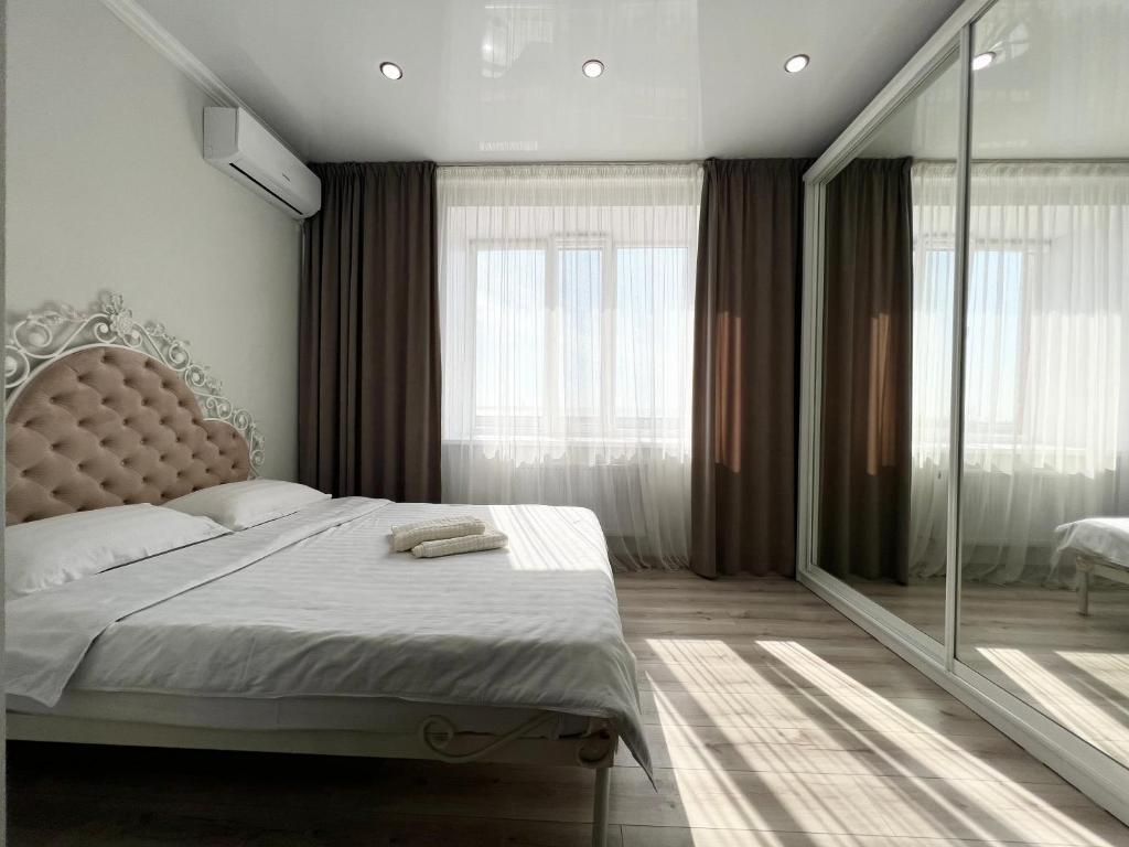 巴甫洛达尔Квартира в элитном ЖК的一间卧室设有一张床和一个大窗户
