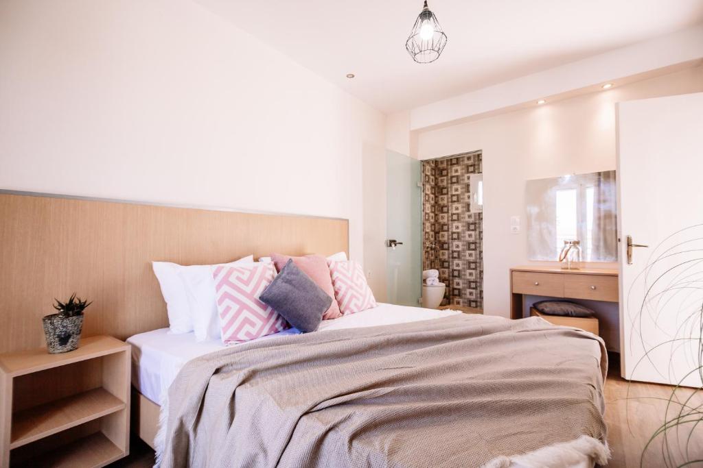 阿凯松Villy Suites的一间卧室配有带粉色和灰色枕头的床
