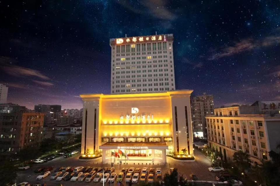 深圳深圳水都假日酒店（火车北站)的一座在晚上有灯的大建筑