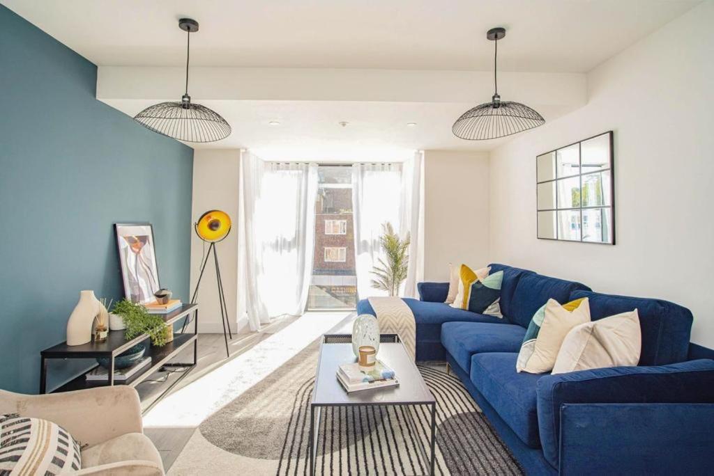 赫默尔亨普斯特德Hemel Apartments- Elite Escape的客厅配有蓝色的沙发和桌子
