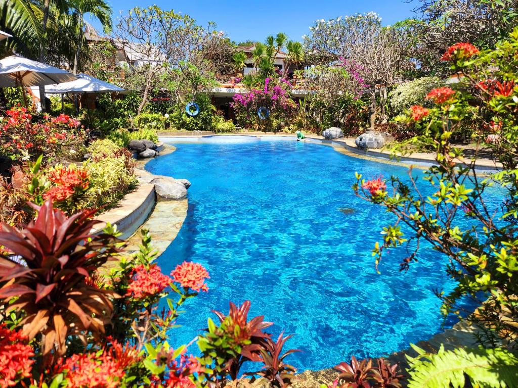 沙努尔斯瓦提卡别墅酒店的花园中种满鲜花的游泳池