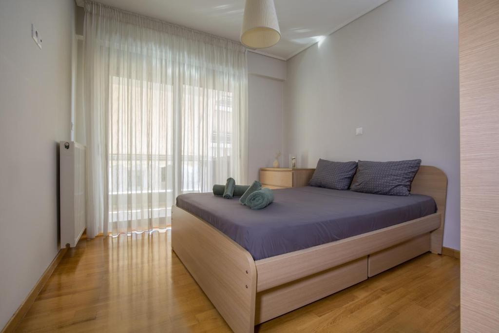雅典Lovely New Βuild Flat Near Metro - Free Parking的一间卧室设有一张床和一个大窗户